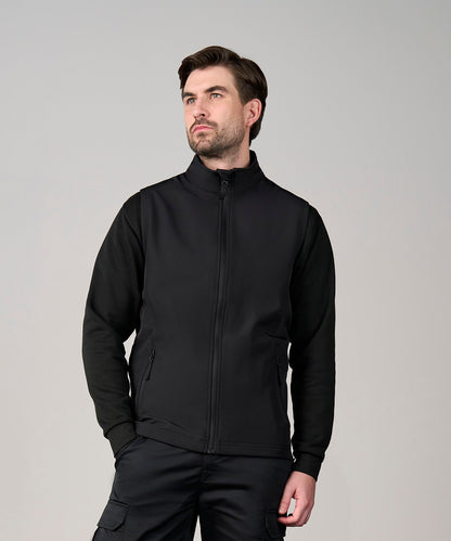 Model wearing the RX550 Pro softshell vest in a work environment, demonstrating its use as a durable and smart professional layer.